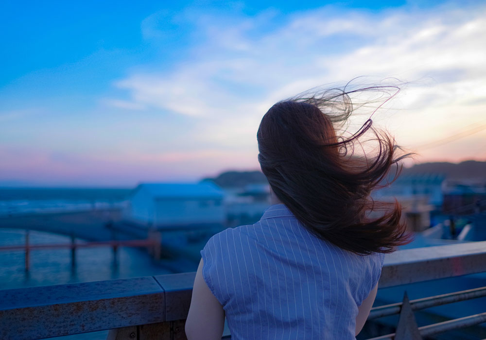 うつ病による落ち込んだ気分で外を見る女性の後ろ姿