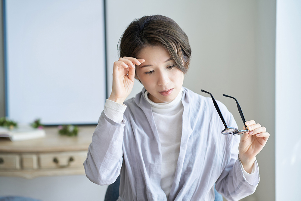 うつ病の薬の効きが悪く頭に手を添える女性