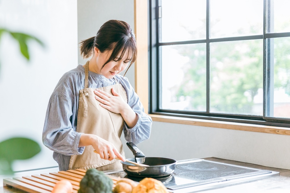 急な動悸に胸を抑える女性